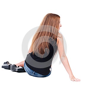 Back view beautiful young woman sitting on floor