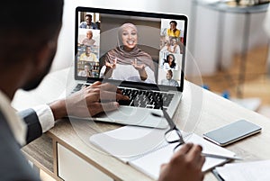 Back view of black businessman communicating with colleagues via video conference