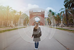 Back view of blonde woman with Arc de Triomf in Barcelona in background