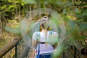 Back view of a blonde woman standing on a bridge with her little baby photo