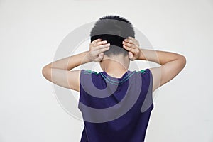 Back view of boy close his ears with two hands.