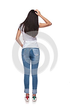 Back view of brunette woman scratching her head