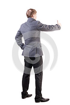 Back view of business man in coat shows thumbs up