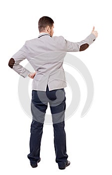 Back view of business man shows thumbs up.