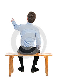 Back view of business man sitting on chair and pointing.