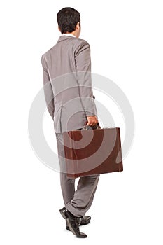 Back view of a business man standing and holding a briefcase