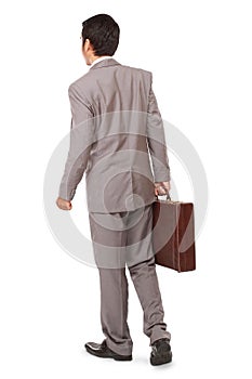 Back view of a business man standing and holding a briefcase