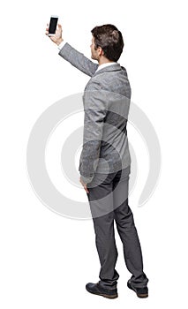 Back view of a business man in a suit making a selfie