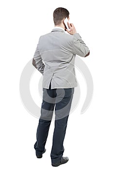 Back view of business man in suit talking on mobile phone.