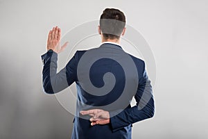 Back view of business man taking fake oath gesture photo