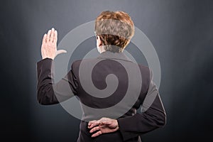 Back view of business senior lady taking fake oath