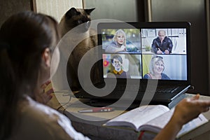 Back view of a business woman talking with her colleagues about an outline in a video conference. Business team using laptop for