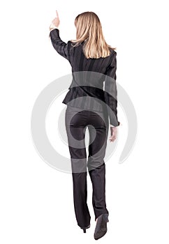 Back view of business woman walking and pointing