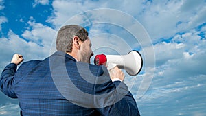 back view of businessman agitate in loudspeaker on sky background photo