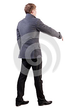 Back view of businessman in coat reaches out to shake hands