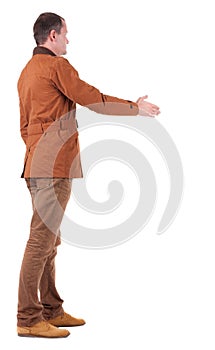 Back view of businessman in movement reaches out to shake hands