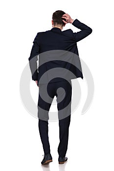 Back view of businessman scratching his head and thinking