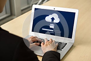 Back view of businessman using cloud drive technology upload save files to internet. Data storage, networking and internet service