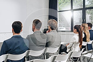 back view of businesspeople sitting on chairs during training