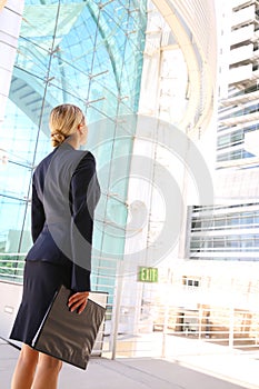 Back view of businesswoman looking at business building