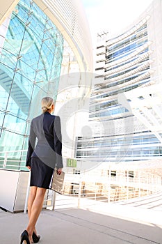 Back view of businesswoman looking at business building