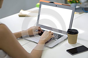 Back view of businesswoman sit at desk in office typing on laptop computer keyboard with white screen
