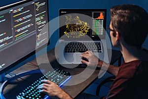 IT developer typing on pc and laptop with programming code on screen, using php language
