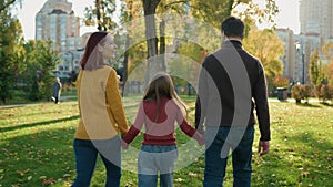 Back view Caucasian happy family weekend holiday at nature outdoors green lawn grass in city autumn park together