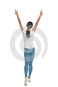 Back view of celebrating casual woman pointing up