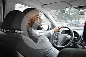 Back view of cheerful black businessman driving car