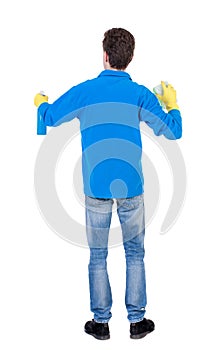 Back view of a cleaner man in gloves with sponge and detergent.