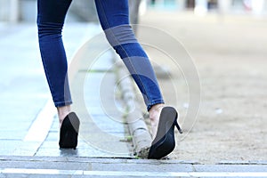 Woman legs with high heels stumbling in the street photo