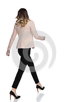Back view of confident businesswoman walking to side