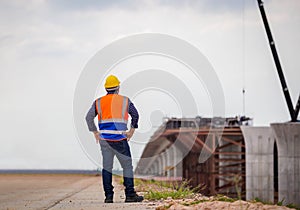 Back view of Construction engineer checking project at the building site, Foreman worker in hardhat at the infrastructure