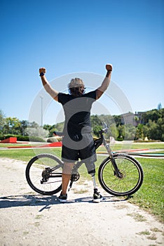Back view of contented person with disability with bicycle