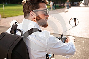 Back view of Cool bearded man in sunglasses with backpack