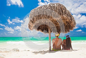 Back view of a couple on a tropical beach vacation