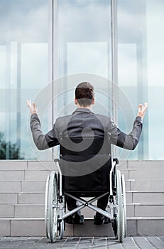 Back view of a disabled man in front of stairs