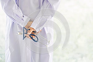 Back view of doctor hand hold stethoscope with blur background