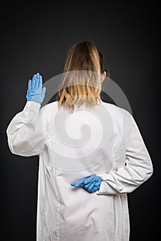 Back view of doctor wearing robe taking fake Hippocratic oath photo
