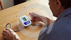 Elderly man measuring the blood pressure at home