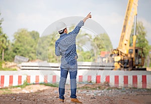Back view of Engineer checking project at the building site, Foreman in hardhat at the infrastructure construction site