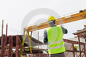 Back view of Engineer man checking project at construction site, Factory foreman worker in hardhat at the precast factory site