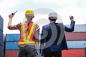 Back view of engineer worker and boss raise hand up in the container cargo shipping area