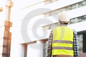 Back view of engineering man construction worker wear safety helmet and wear reflective clothing for the safety of the work operat