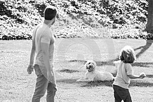 Back view of family with dog relaxing in park.