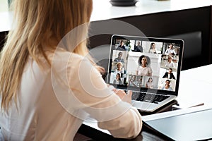 Back view of female employee have video call on laptop