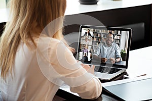 Back view of female employee have web conference with colleagues