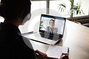 Back view of female employee have web conference with coworker