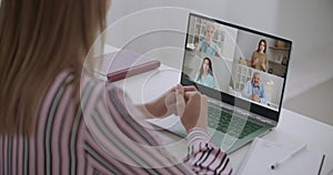 Back view of female employee speak talk on video call with diverse multiracial colleagues on online briefing, woman